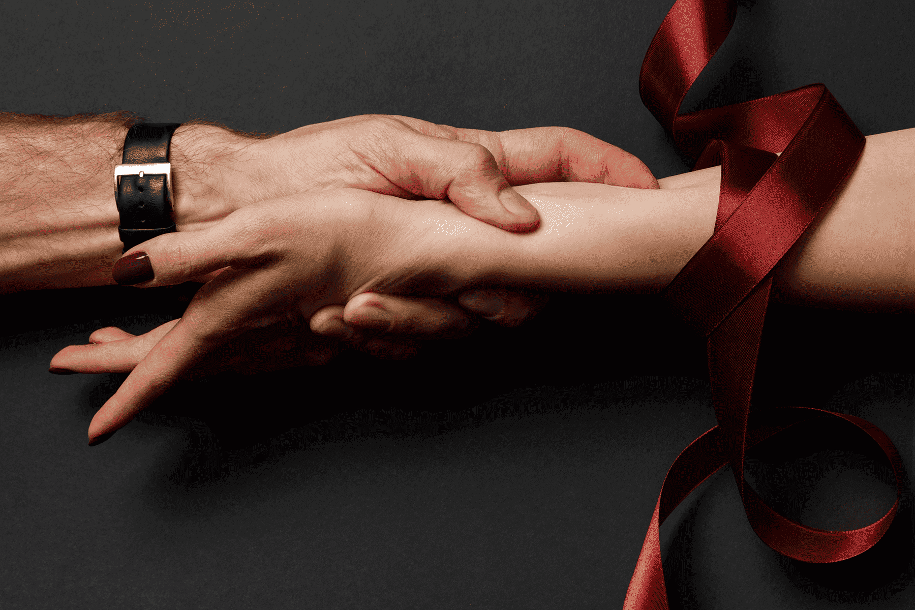 tay nam nắm tay nữ có ruy băng đỏ