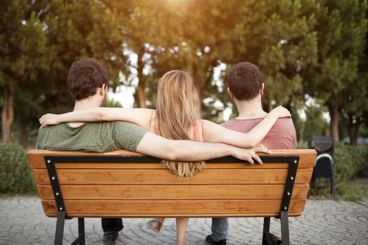 Ba người ngồi trên ghế trong công viên