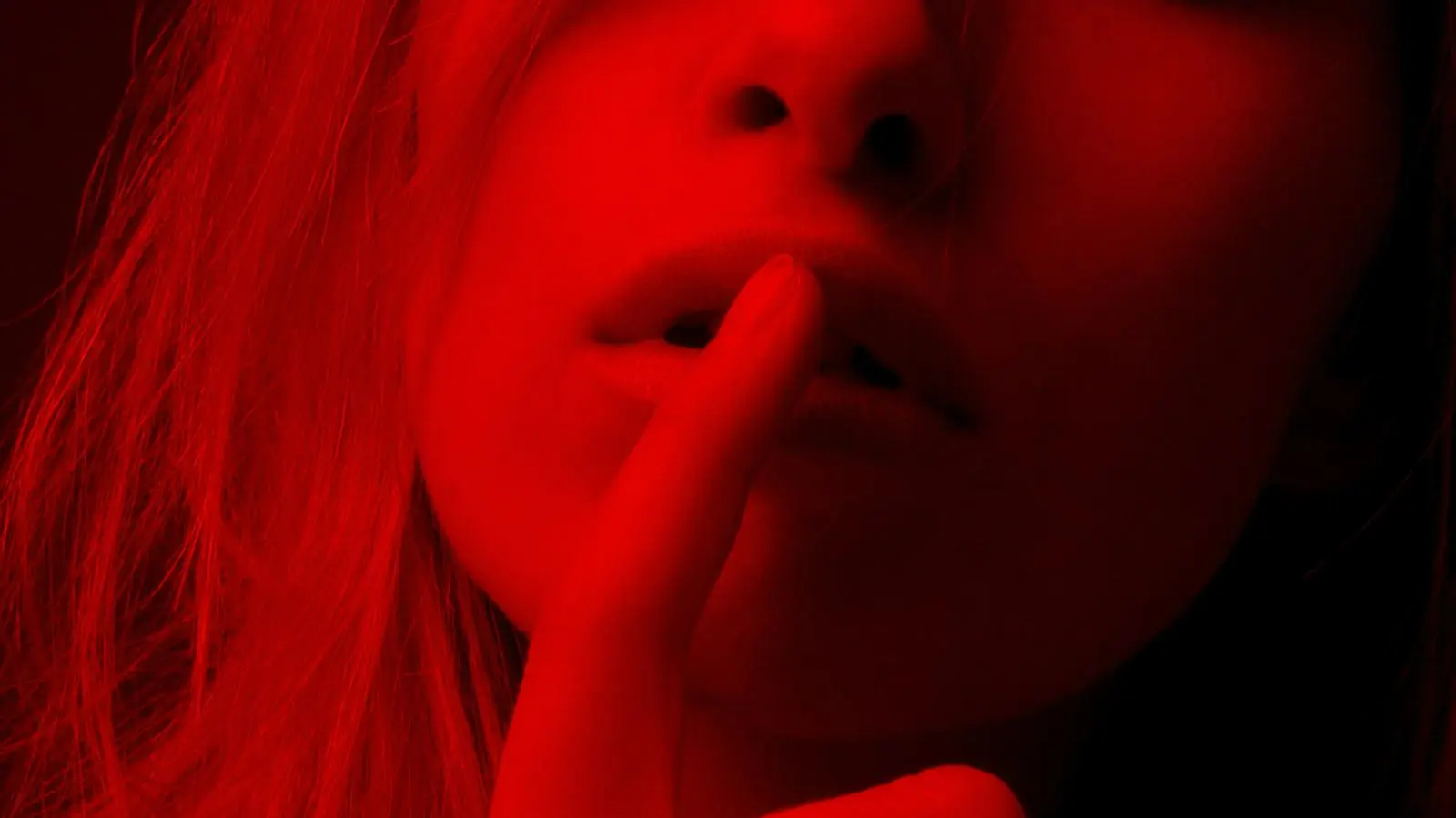 Người nữ tóc dài đang làm động tác giữ im lặng