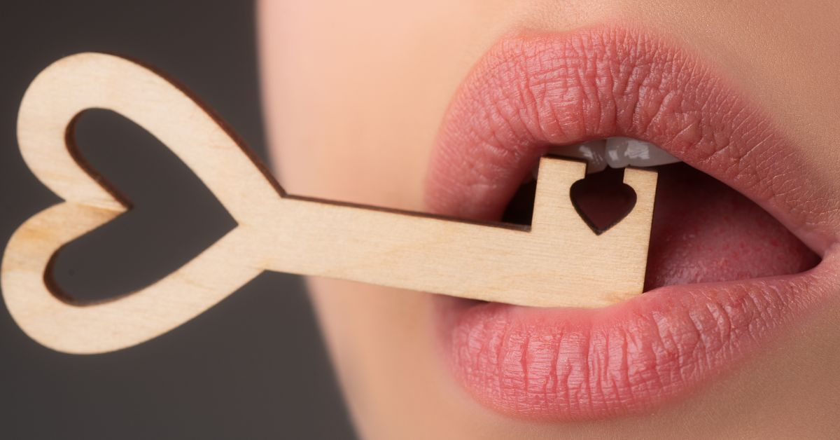 Môi của nữ đang ngậm chìa khóa bằng gỗ