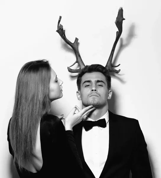 cô gái nâng mặt chàng trai đang đội sừng hươu